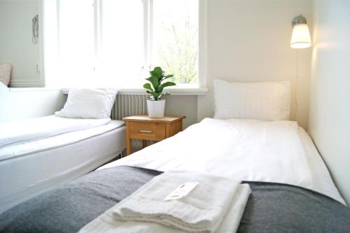 a small bedroom with two beds and a window at Alvaret Hotel & Hostel in Löttorp