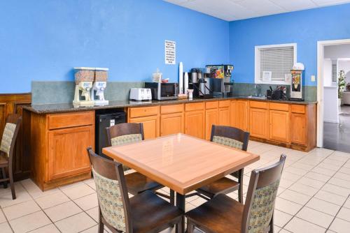a kitchen with a wooden table and chairs and a counter at Americas Best Value Inn Clute in Clute