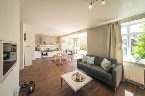 ein Wohnzimmer mit einem Sofa und einem Tisch in der Unterkunft Gutshaus Krummin Usedom in Krummin