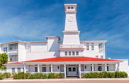 Un edificio blanco con una torre de reloj en la parte superior. en Lighthouse Inn at Aransas Bay, en Rockport