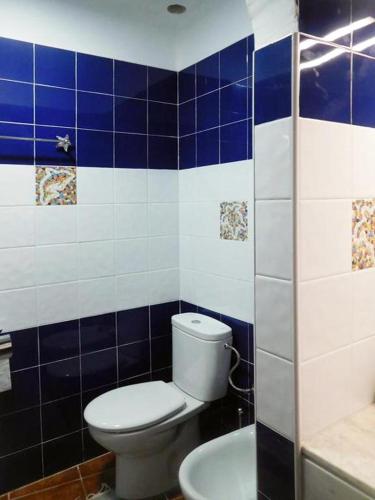 a blue and white bathroom with a toilet and a sink at Reby Bastian Beach in Costa Teguise