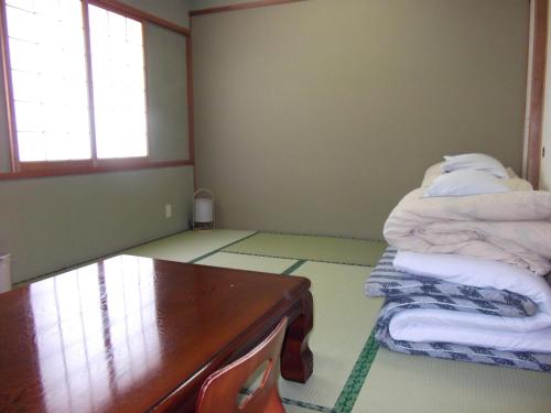 a room with a desk and a bed with towels at Asahi City Inn Hotel in Takaoka