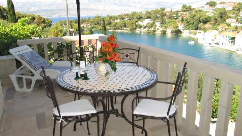 a table and chairs on a balcony with a view of the water at Apartments Splitska Dream in Splitska