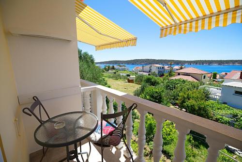 a balcony with a table and chairs and a view of the water at Balen Guest house in Rab