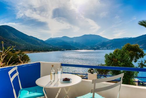 a table and chairs on a balcony with a view of a lake at Antoniadi Rooms in Livadia
