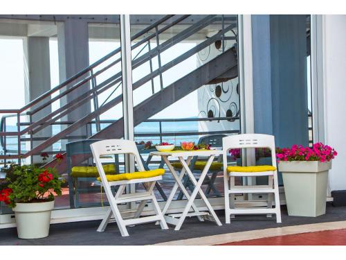 two chairs and a table on a balcony at IDRO Studio Apartments directly at the beach in Split