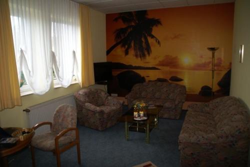 ein Wohnzimmer mit einem Sofa, Stühlen und einem Tisch in der Unterkunft Weser Wasserbetten Hotel Baxmann in Hessisch Oldendorf