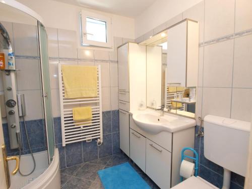 a white bathroom with a sink and a shower at Apartment Marija 1389 in Fažana
