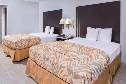 Habitación de hotel con 2 camas y teléfono en Express Inn Weslaco/Mercedes en Weslaco