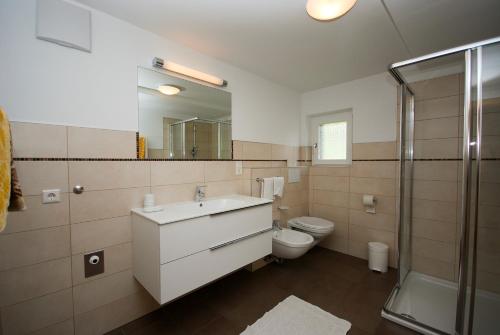 y baño con lavabo, aseo y ducha. en Villgraterhof en Sesto