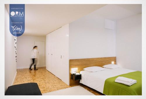 a woman standing in a hotel room with a bed at ORM - Ribeira Apartments in Porto