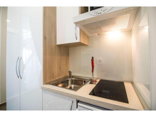 a small kitchen with a sink and a stove at IDRO Studio Apartments directly at the beach in Split