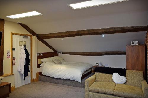 um quarto com uma cama, um sofá e uma cadeira em The Wharf Stourport em Stourport