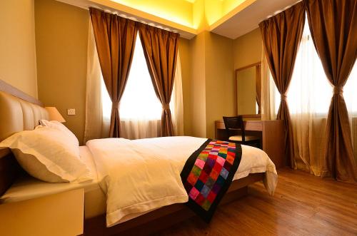 a bedroom with a bed and a window at Jetty Suites Apartments in Malacca
