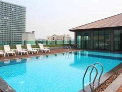 a large swimming pool with chairs and a building at The Stay Hotel "SHA Certified" in Pattaya