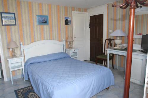 a bedroom with a bed and a desk and a computer at Hotel Royal Albion in Mesnil-Val-Plage