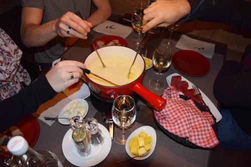 a group of people sitting at a table with a pot of food at Hotel Sportcenter Fünf Dörfer AG in Zizers