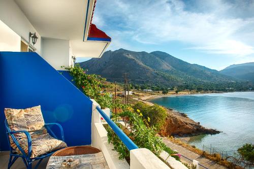 a blue balcony with a chair and a view of the water at Antoniadi Rooms in Livadia