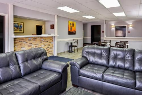 a waiting room with two leather couches and a bar at Express Inn Weslaco/Mercedes in Weslaco