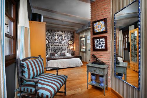 1 dormitorio con 1 cama y 1 silla en una habitación en Hotel Boutique Maribel (Adult Only), en Alquézar