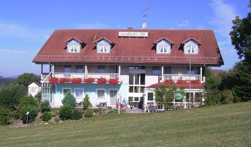 a large house with a red roof on a hill at Landhotel Eibl in Röhrnbach