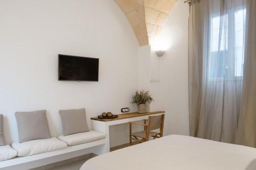 um quarto branco com uma cama e um sofá em Hotel Nou Sant Antoni em Ciutadella