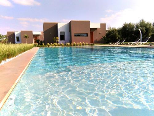 a swimming pool in front of a building at Villa Jardins D'Isa in Marrakech