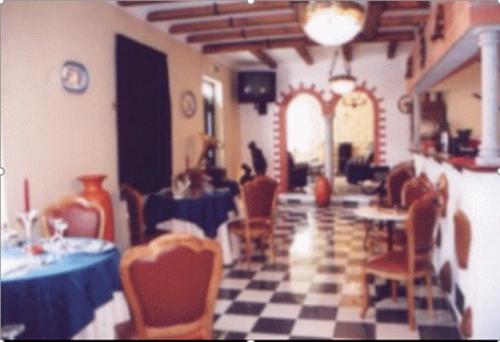 a dining room with tables and chairs and a checkered floor at Hospedaria A Varanda in Alvito