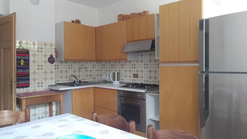 a kitchen with wooden cabinets and a stainless steel refrigerator at Piller Roner Rosa in Sappada