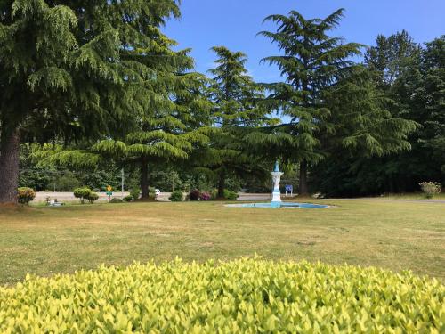 a park with a fountain in the middle of a field at Fuller Lake Chemainus Motel in Chemainus
