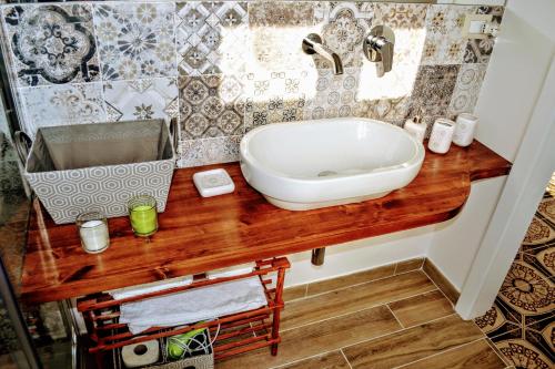 uma casa de banho com um balcão de madeira e um lavatório em La casa di Aneupe em Siracusa