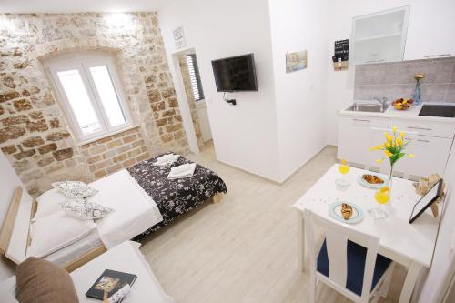 una pequeña sala de estar con cama y mesa. en Apartments Grisogono en Zadar