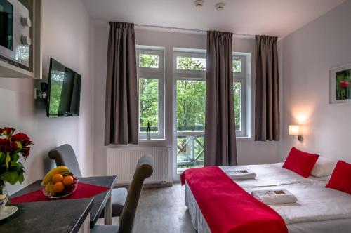 Habitación de hotel con cama, mesa y ventana en Willa Tęcza en Szczawnica