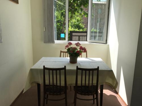 a dining room table with a vase of flowers on it at Aregak B&B and Tours in Goris