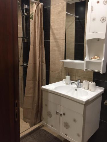 een badkamer met een witte wastafel en een douche bij Апартамент Danaya 1 in Varna