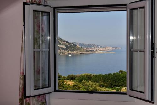 an open window with a view of the water at Agriturismo Un Mare di Fiori in Ventimiglia