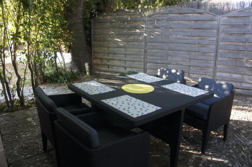 une table et des chaises noires avec une plaque jaune dans l'établissement Lavender Apartment, à Argelès-sur-Mer