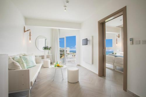 a white living room with a couch and a table at Infinity Blu - Designed for Adults by Louis Hotels in Protaras