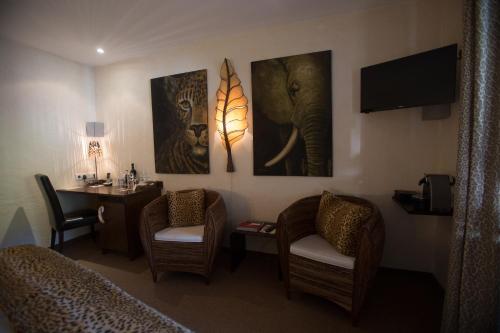 a hotel room with two beds and a desk and paintings at Hotel Heiligenstein in Baden-Baden