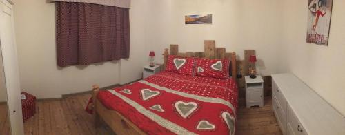 a bedroom with a bed with a red comforter at Le samantine in Baceno