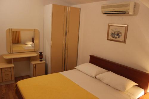 a small bedroom with a bed and a mirror at Apartments Z in Dugi Rat