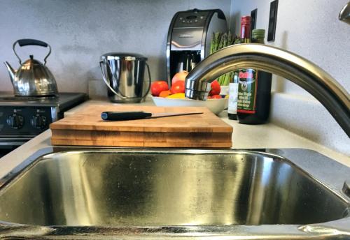 a kitchen counter with a sink and a cutting board at Chalet 44 in Grand Barachois
