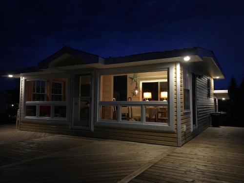 a small house with a deck at night at Chalet 44 in Grand Barachois