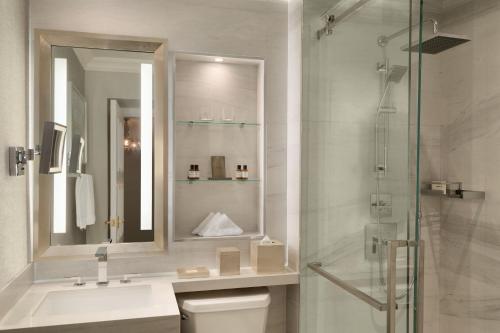 a bathroom with a sink and a shower with a mirror at Fairmont Empress Hotel in Victoria