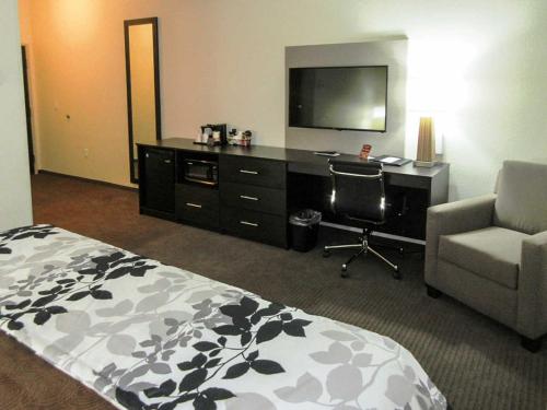a hotel room with a bed and a desk with a television at Sleep Inn & Suites West-Near Medical Center in Rochester