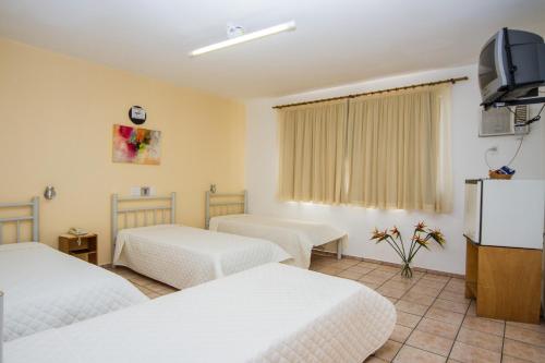 A bed or beds in a room at Santa Maria Hotel