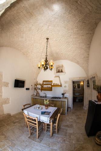 a kitchen and dining room with a table and chairs at Agriturismo Grotta Di Figazzano in Cisternino