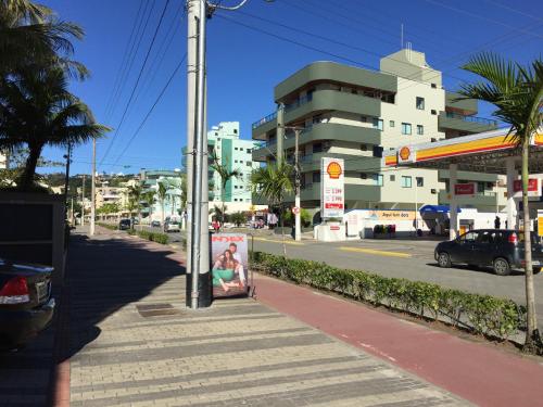 a sidewalk with a sign on the side of a street at Pousada Kia Ora Bombinhas in Bombinhas