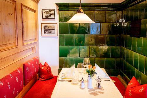 a dining room with a table and a green tiled wall at Gasthaus Zum Kreuz in Sankt Märgen