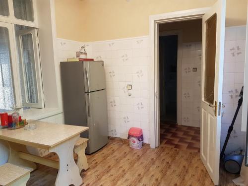uma cozinha com uma mesa e um frigorífico em House #1 em Kutaisi